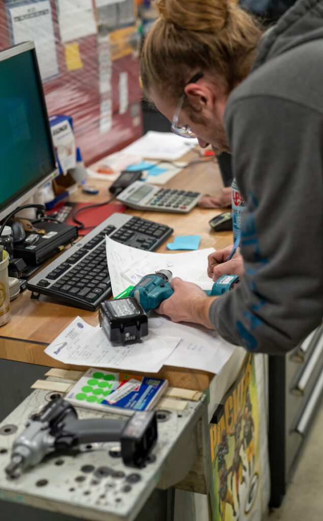 employee writing notes for calibration of torque