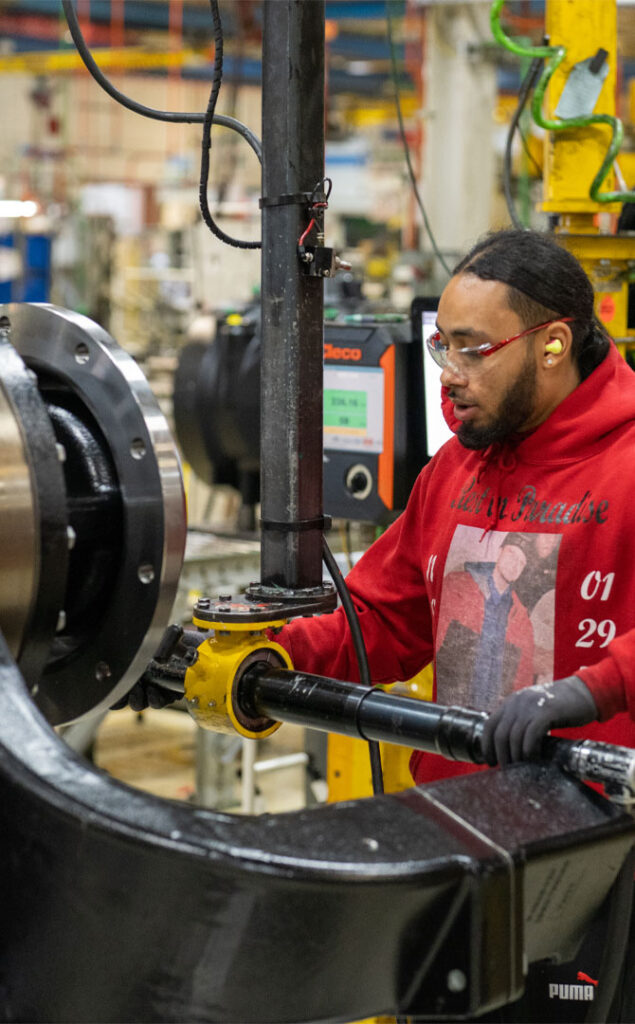 employee working on large machine manufacturing tools